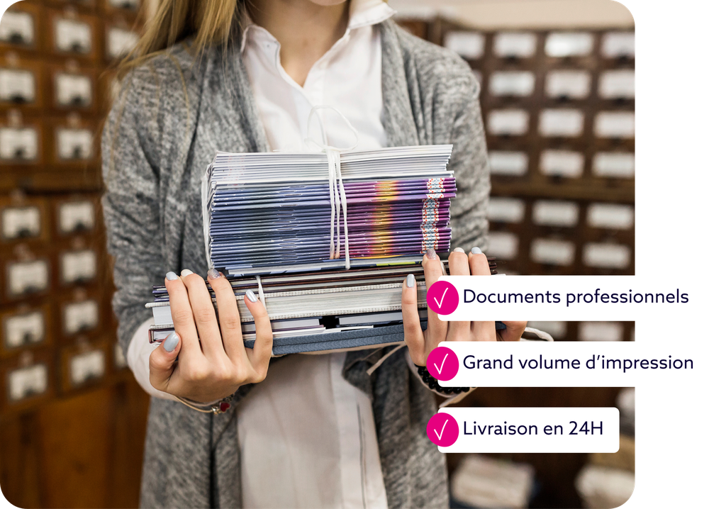 Personne tenant une grande pile de brochures et livrets fraîchement imprimés, illustrant la capacité d'impression en gros volume.